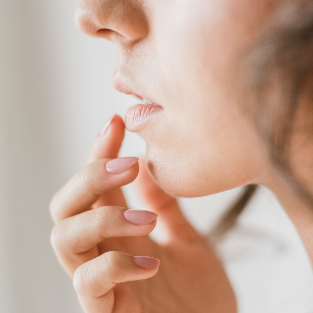 Frau cremt sich die Lippen ein