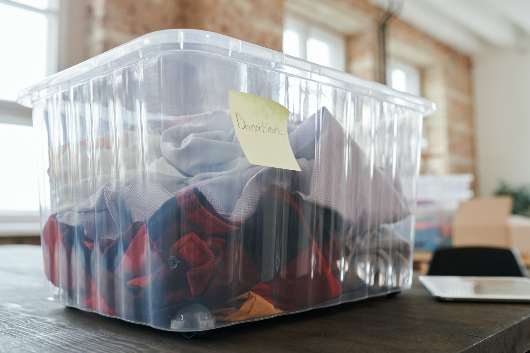 Kleiderspenden Kleidung in einer Kiste mit der Aufschrift "Donation"